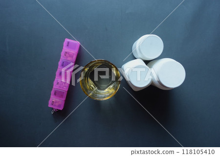 top view of medical pills in a pill box and glass of water of table top view of medical pills in a pill box and glass of water of table 118105410
