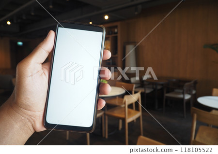 A hand holding a smartphone in a trendy cafe radiating a contemporary atmosphere 118105522