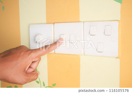 A finger turning on lighting switch . A finger turning on lighting switch . 118105576