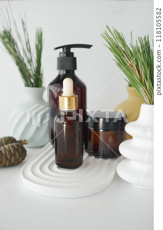 Bottle of pine essential oil and tree branch on white background 118105582