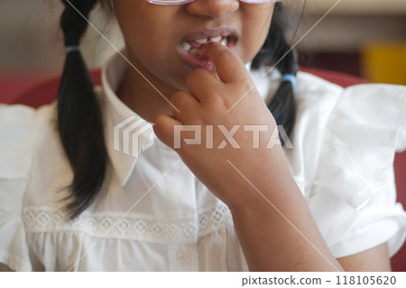 child girl biting her nails at home, 118105620