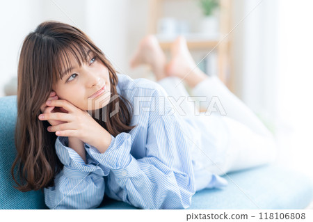Young woman relaxing in the living room 118106808