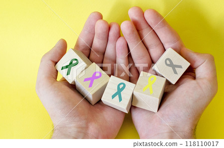 World Cancer Day. Colorful ribbons on cubes in hands, cancer awareness. World Cancer Day. Colorful ribbons on cubes in hands, cancer awareness. 118110017