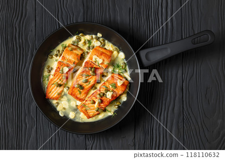 salmon piccata with lemon caper sauce in a pan 118110632