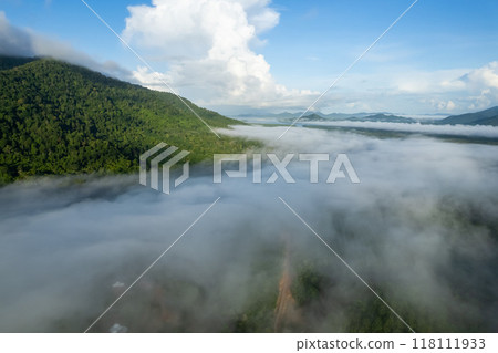 Aerial view drone shot of flowing fog waves on mountain tropical rainforest,Bird eye view image over the clouds Amazing nature background with clouds and mountain peaks 118111933