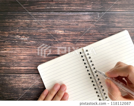 Female hand writing notes on notebook Female hand writing notes on notebook 118112087