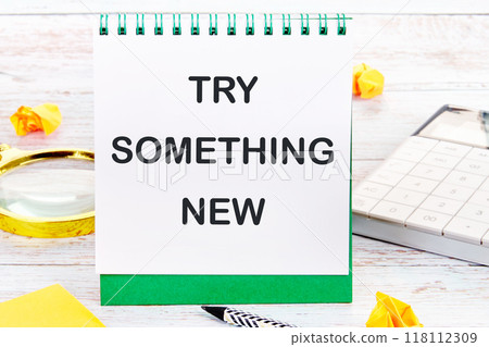 TRY SOMETHING NEW words on a blank sheet of a desktop notebook 118112309
