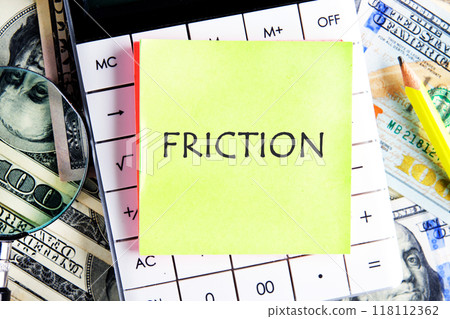 Friction concept. Friction word on a yellow sticker on the background of a calculator and American dollar bills Friction concept. Friction word on a yellow sticker on the background of a calculator and American dollar bills 118112362