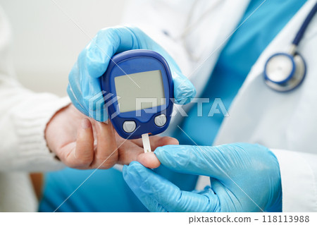 Asian doctor using digital glucose meter for check sample blood sugar level to treatment diabetes. Asian doctor using digital glucose meter for check sample blood sugar level to treatment diabetes. 118113988