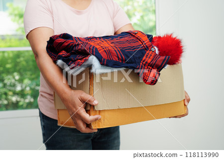 Clothes donations in cardboard box for volunteer. Clothes donations in cardboard box for volunteer. 118113990
