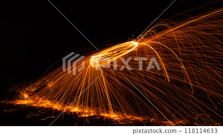 Swing fire Swirl steel wool light photography over the stone with reflex in the water Beautiful light in the sunrise or sunset time, long exposure speed motion style Swing fire Swirl steel wool light photography over the stone with reflex in the water Beautiful light in the sunrise or sunset time, long exposure speed motion style 118114633