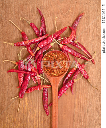 Dried chilies with chili powder, pepper, and  in a wooden spoon Spicy seasoning Healthy food, top view 118116245