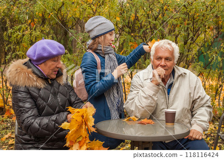 Smiling grandfather, grandmother and granddaughter, autumn portrait 118116424