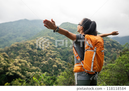 Cheering happy woman enjoying the view on morning mountain top 118118584