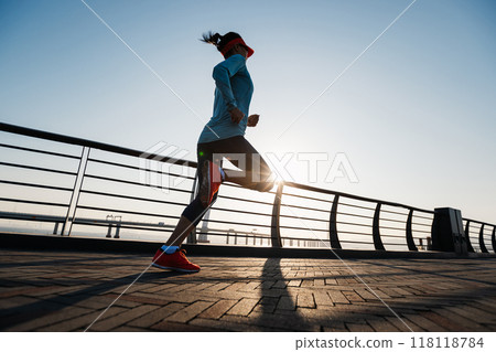 Fitness woman runner running on seaside bridge Fitness woman runner running on seaside bridge 118118784