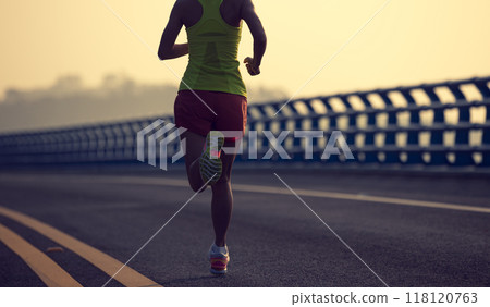 Fitness woman runner running on seaside bridge 118120763