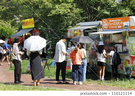 人們在活動廣場的廚房車裡排隊。坐在草地上，吃吃喝、聊天 118121114