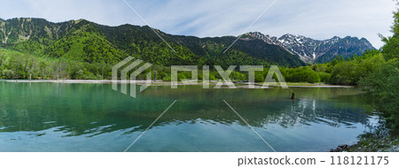Kamikochi, a scenic mountain spot in Azumi, Matsumoto City, Nagano Prefecture, Japan. Taisho Pond surrounded by fresh greenery with the Hotaka mountain range visible in the background 118121175