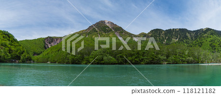 Kamikochi, a scenic mountain spot in Azumi, Matsumoto City, Nagano Prefecture, Japan. Taisho Pond surrounded by fresh greenery and Mount Yake visible in the background 118121182