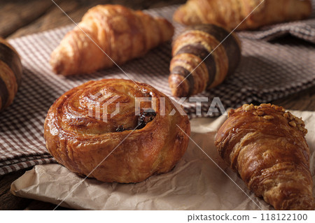 Freshly baked Raisin Danish Pastry and croissants. Arranged on a cloth and parchment paper. Freshly baked Raisin Danish Pastry and croissants. Arranged on a cloth and parchment paper. 118122100