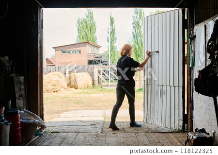 Person Opening Barn Door To Sunny Agricultural Farmyard Person Opening Barn Door To Sunny Agricultural Farmyard 118122325