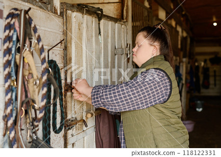 Caucasian Woman Locking Barn Door in Rustic Setting 118122331