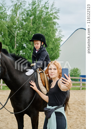 Taking Selfie with Kid Riding Black Horse 118122523