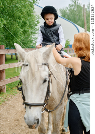 Riding Horse While Wearing Safety Helmet on Farm Riding Horse While Wearing Safety Helmet on Farm 118122624