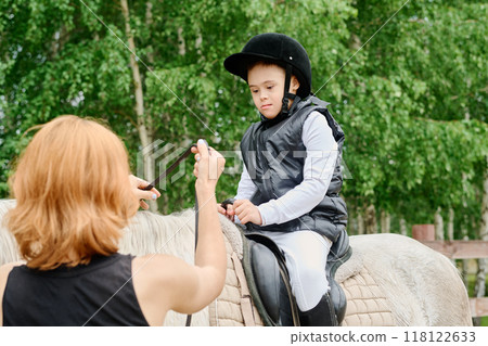 Guiding Young Rider During Equestrian Training Outdoors Guiding Young Rider During Equestrian Training Outdoors 118122633