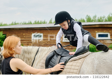 Helping Young Boy Saddle Horse During Training Session Helping Young Boy Saddle Horse During Training Session 118122642