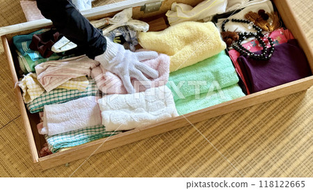 他戴著工作手套,抽屜裡放著很多毛巾和念珠。 他戴著工作手套,抽屜裡放著很多毛巾和念珠。 118122665