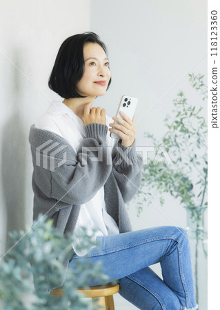 操作智慧型手機的中年婦女 118123360