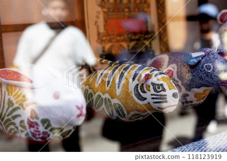 Old castle town streetscape. Folk craft dolls of the zodiac displayed in a shop window. 118123919