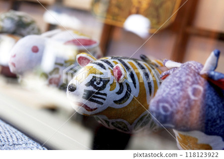 Old castle town streetscape. Folk craft dolls of the zodiac displayed in a shop window. 118123922