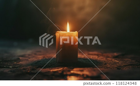 Picture of a candle glowing in the darkness, representing resilience and optimism 118124348