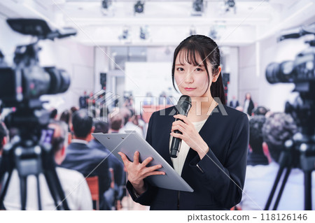A female reporter reporting from a press conference A female reporter reporting from a press conference 118126146