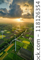 Windmill park in the Netherlands, aerial view with symmetrical turbines and vibrant sunset over agricultural land, eco-friendly and serene atmosphere. Windmill park clean energy nehterlands 118126354