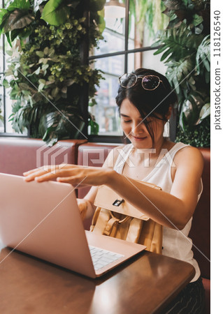 Woman finished her work and turning off the laptop computer. 118126540