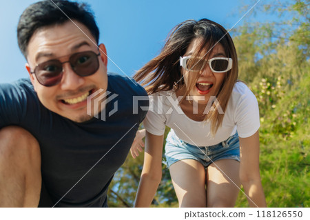 Cheerful and playful couple lover is taking selfie photo with bright sky. Cheerful and playful couple lover is taking selfie photo with bright sky. 118126550