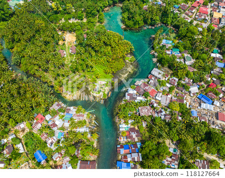 Blue clear water over the Bogac Cold Spring surrounded by villages and tropical forest. Surigao del Sur, Philippines. 118127664