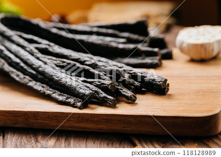 Rustic black meat sticks with herbs and spices on board, perfect for gourmet and food photography Rustic black meat sticks with herbs and spices on board, perfect for gourmet and food photography 118128989
