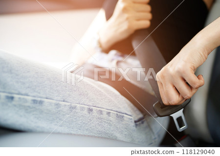 Close Up of people business woman hand fastening seat safety belt in car for safety before driving on the road. concept transport travel. soft focus. Close Up of people business woman hand fastening seat safety belt in car for safety before driving on the road. concept transport travel. soft focus. 118129040