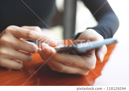 woman is playing games on smart phone woman is playing games on smart phone 118129294