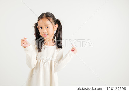 Portrait of happy Asian young kid girl, confidently smiling showing mini heart sign with finger studio shot isolated on white background. Kindergarten child expressing love and joy for Valentine's Day 118129298