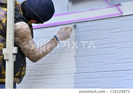A painter carefully paints the details with a brush - residential painting work A painter carefully paints the details with a brush - residential painting work 118129873