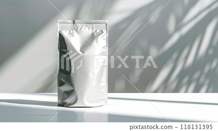 A sleek, reflective silver package stands prominently on a white surface 118131395