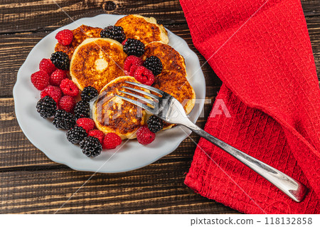 Fresh cottage cheese pancakes with raspberry blackberry on a white plate 118132858