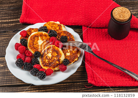 Fresh cottage cheese pancakes with raspberry blackberry on a white plate Fresh cottage cheese pancakes with raspberry blackberry on a white plate 118132859