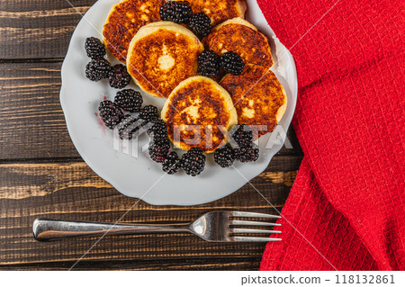 Cottage cheese pancakes with fresh blackberries on a white flat white plate Cottage cheese pancakes with fresh blackberries on a white flat white plate 118132861