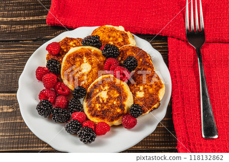 Fresh cottage cheese pancakes with raspberry blackberry on a white plate Fresh cottage cheese pancakes with raspberry blackberry on a white plate 118132862